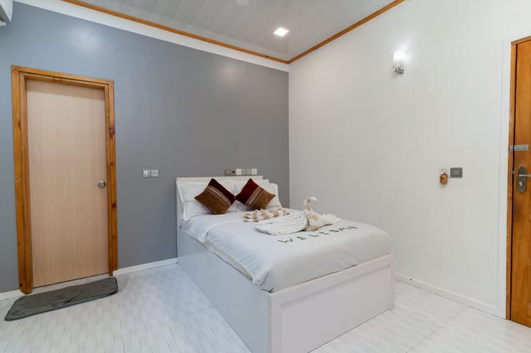Bedroom 2: double bed with coloured pillows and two doors