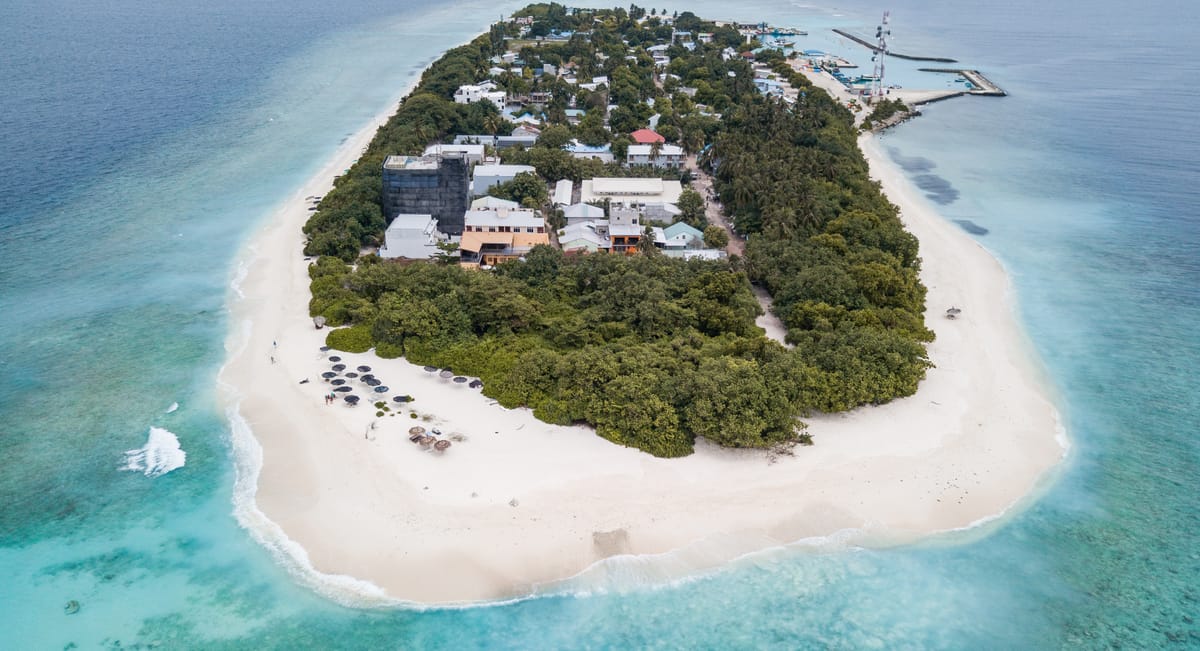 Aerial view of Ukulhas island, Maldives — the turquoise lagoon and white reef surrounding Maafolhey Han'dhaan